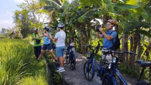 Guests taking pictures of rice fields and surrounding area while on the e-bike tour in south Ubud